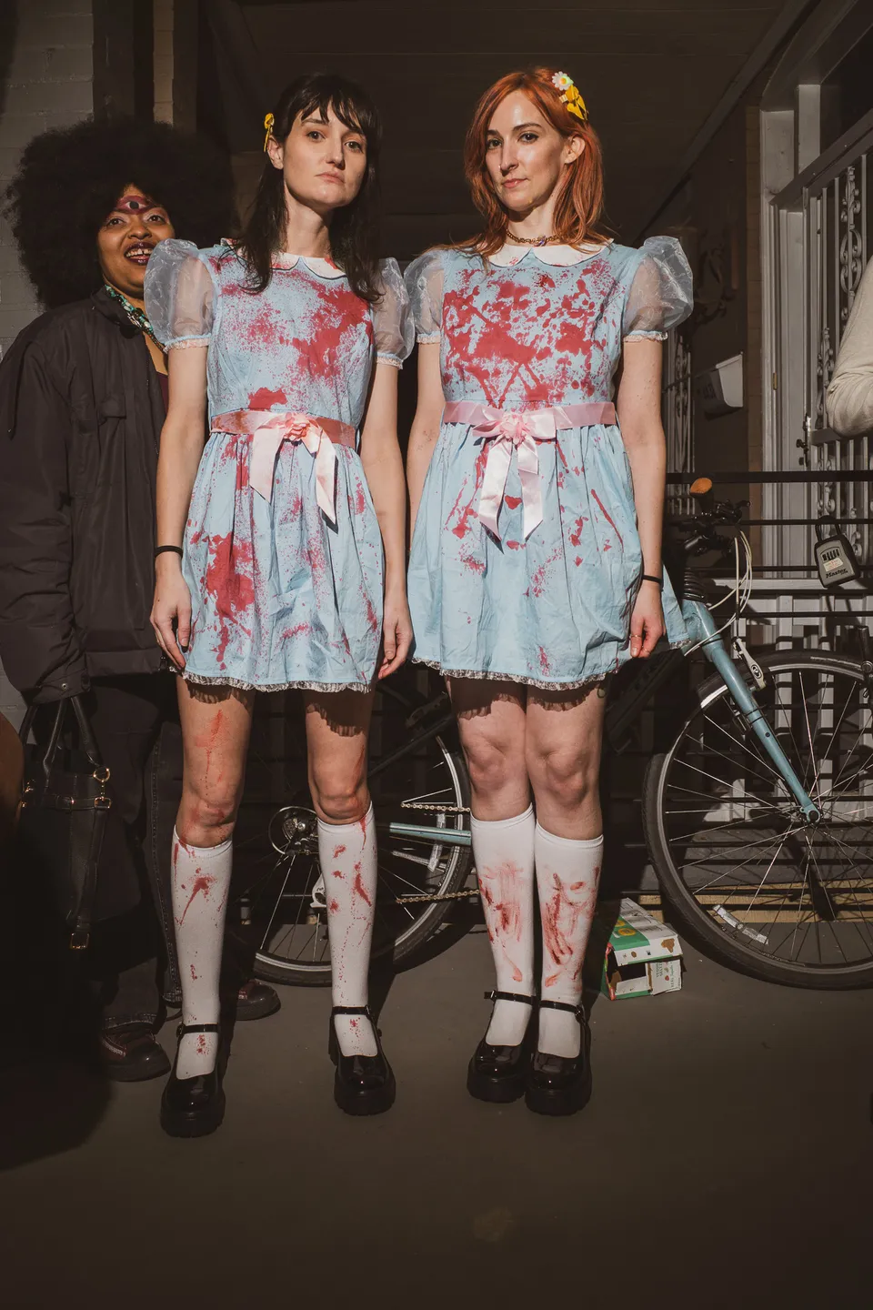 Twins in blood-spattered dresses for Halloween