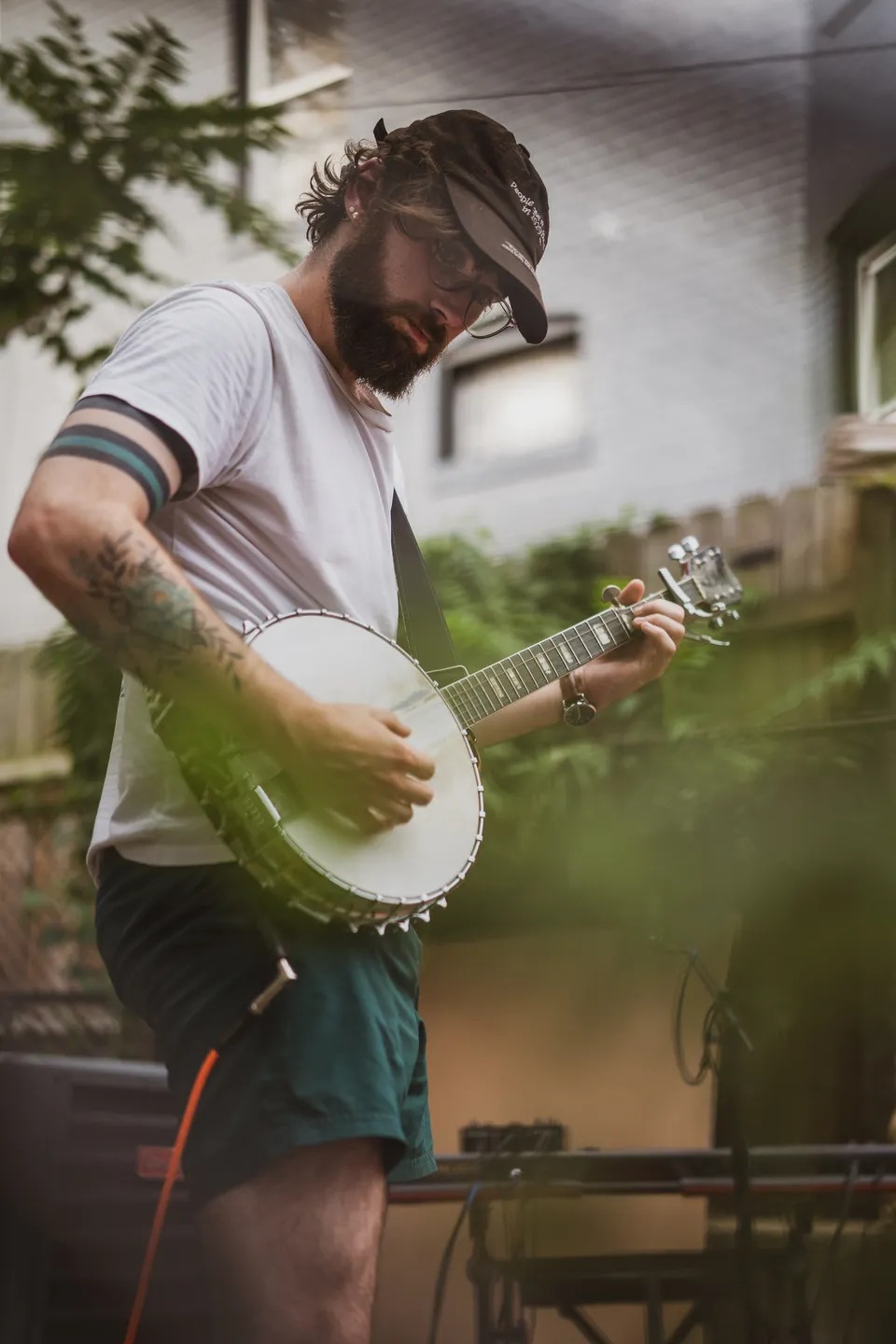 Banjo player outdoors among the greenery
