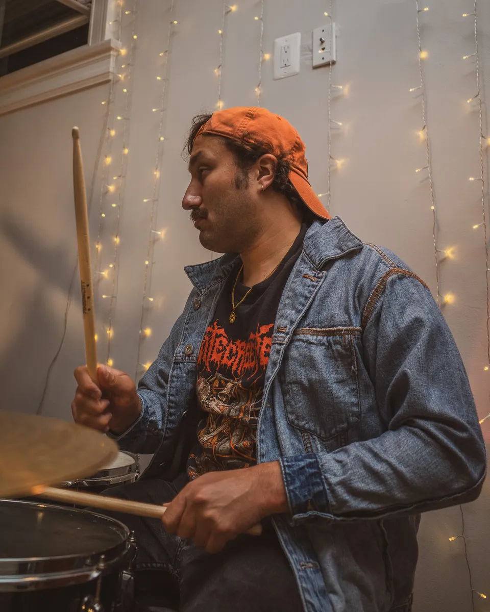 Drummer in a bandana under string lights